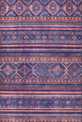 Patterned rug with blue and orange stripes and geometric designs.