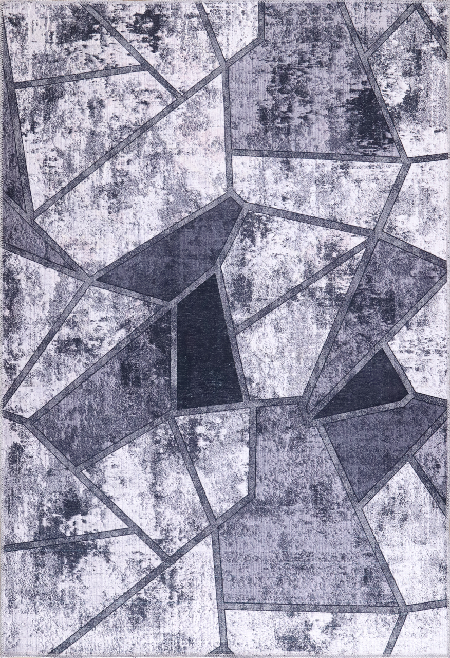 Geometric patterned rug with black and gray shapes on a textured background